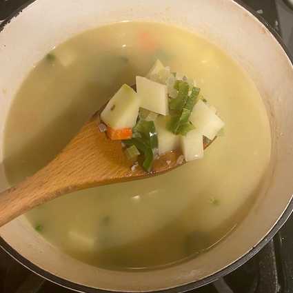 Pour in **4 cups of stock** and add in the **diced potatoes**. Add additional liquid (water or stock) if needed to cover the potatoes. Add in minced cilantro stems if using. Bring to a boil, then reduce to a simmer, cover, and let cook for 10-15 minutes until the potatoes are fully cooked.