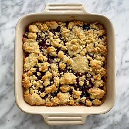 Reduce the oven temperature to 350°. Spread the filling over the base. Mix the almonds with the remaining crust and drop pieces of the crust across the top of the filling (it won't completely cover the filling). Bake at 350° for 25-30 minutes until the top crust is browned. Cool in the pan, slice, and enjoy!